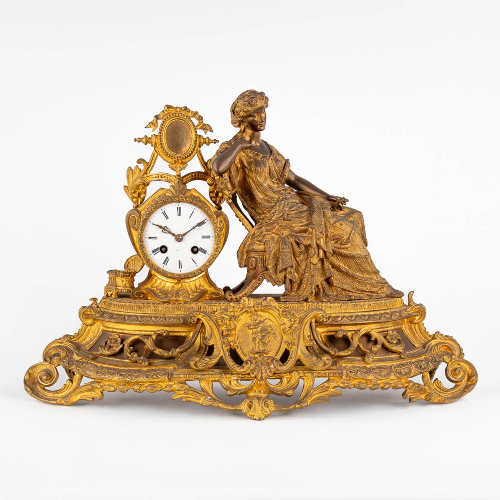A mantle garniture clock, gilt bronze decorated with a Lady in a sofa. Late 19th C. (D:18 x W:56 x H