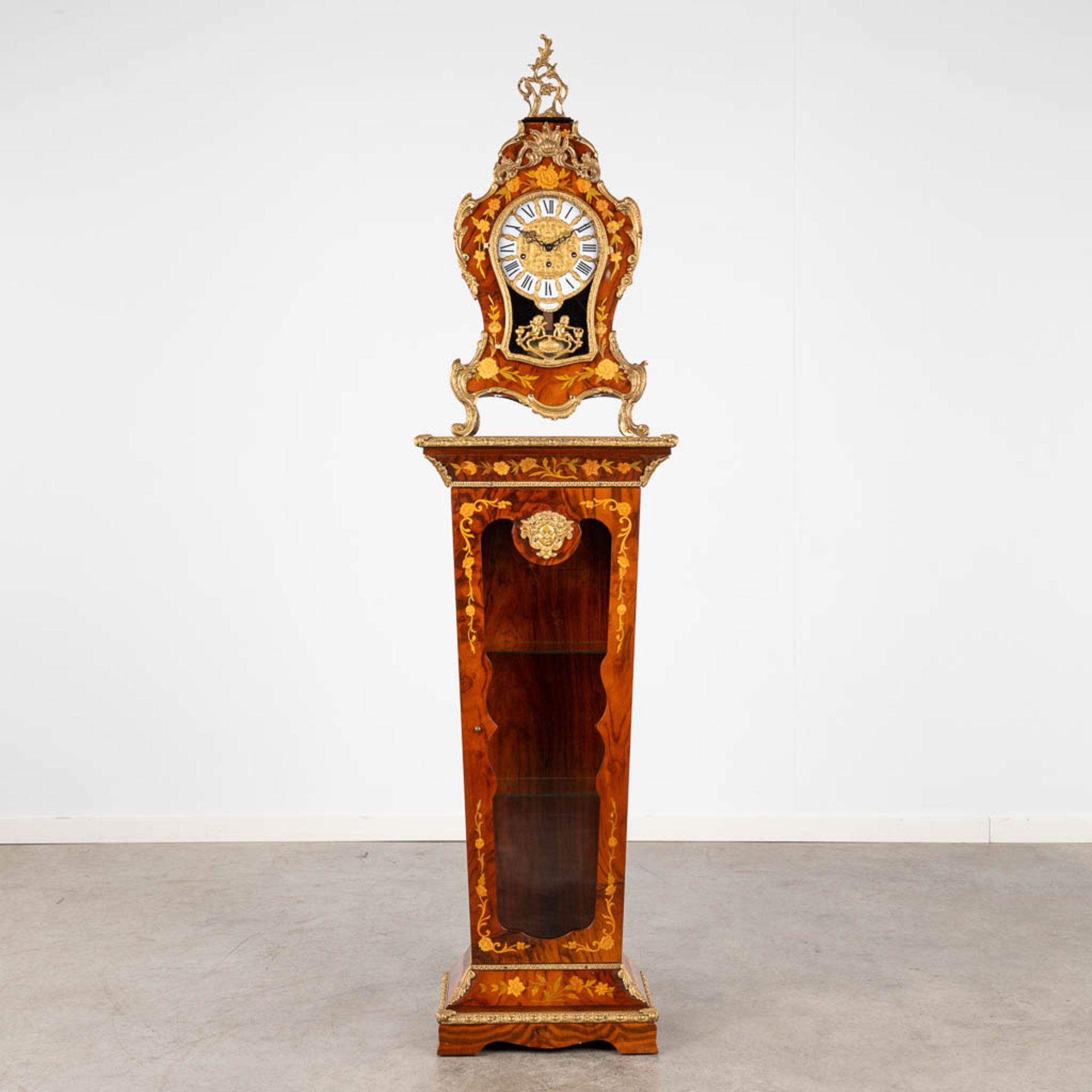 A Cartel clock on a matching pedestal, marquetry inlay and mounted with bronze. 20th C. (D:25 x W:48