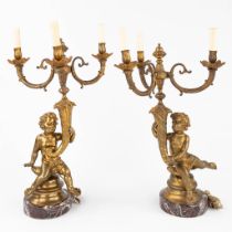 A pair of table lamps or candelabra, gilt bronze on a marble base, decorated with Putti. 20th C. (H: