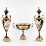 A.C.F. A three-piece mantle garniture, A bowl with two vases, porcelain mounted with bronze. 20th C.