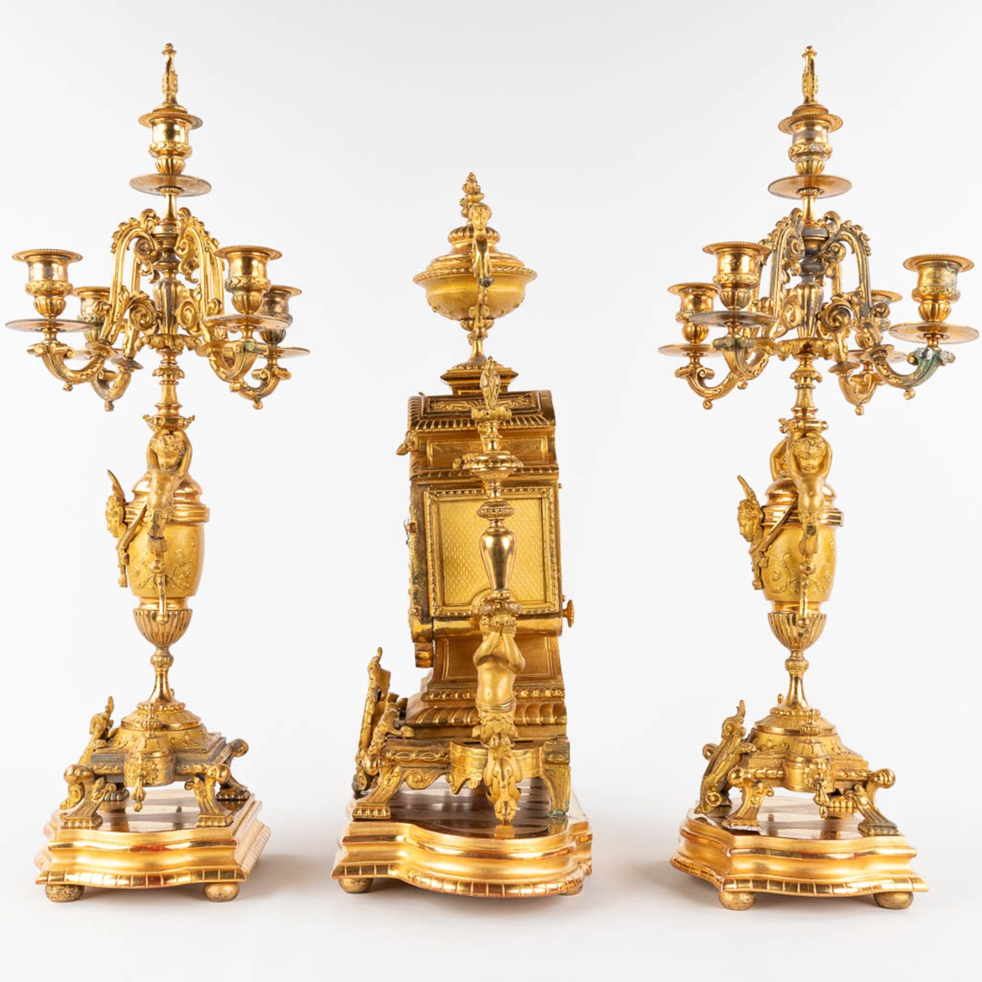 A three-piece mantle garniture clock and candelabra, gilt spelter, decorated with putti. Circa 1900. - Image 8 of 19