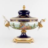 A large tureen with a lid decorated with bronze and porcelain figurines and hand-painted decor. 20th