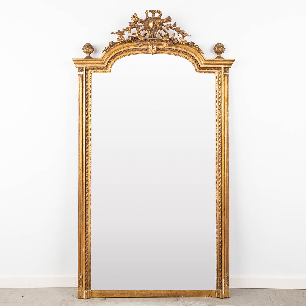 An antique mirror, gilt wood and stucco in Louis XVI style. Circa 1900.  (W:91 x H:160 cm)