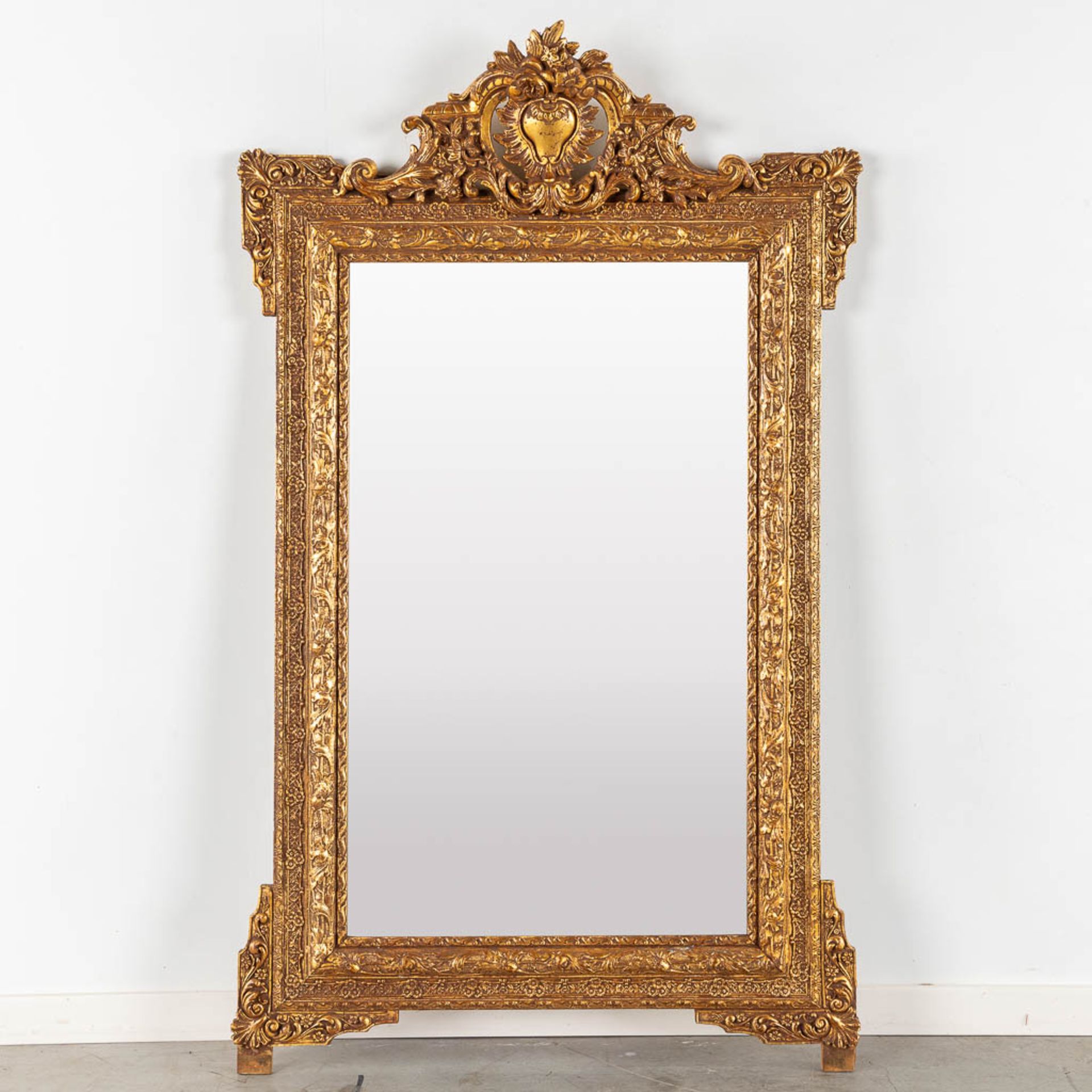 A mirror, sculptured wood and gilt stucco. Circa 1900. (W:135 x H:85 cm)