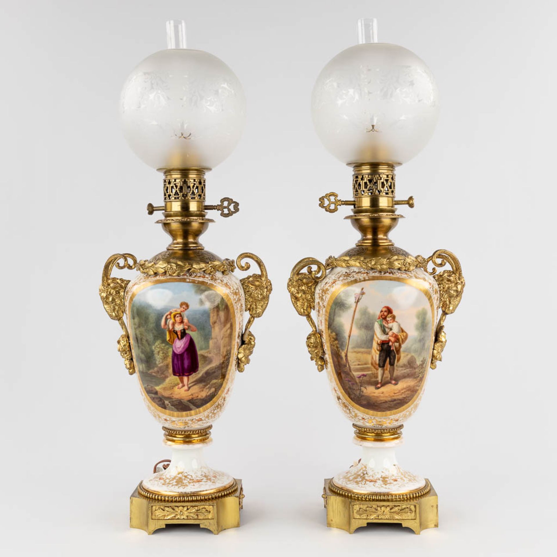 A pair of antique oil lamps reformed into table lamps, hand-painted decor and mounted with bronze. 1