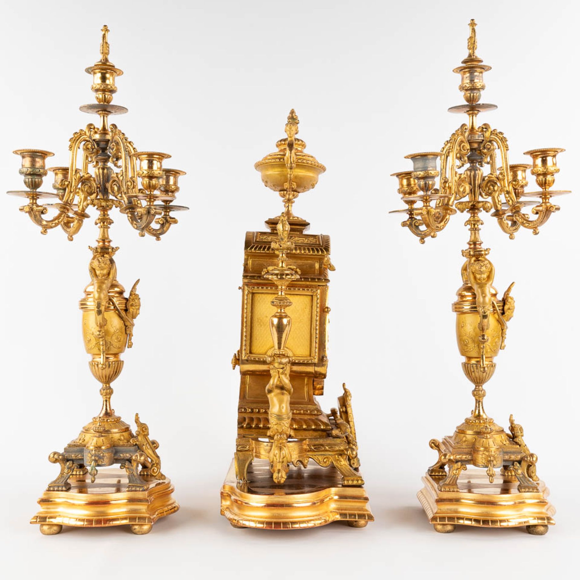 A three-piece mantle garniture clock and candelabra, gilt spelter, decorated with putti. Circa 1900. - Image 4 of 19