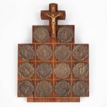 A wall plaque with 14 'Stations of the cross', medals and a crucifix. (W:22 x H:30 cm)