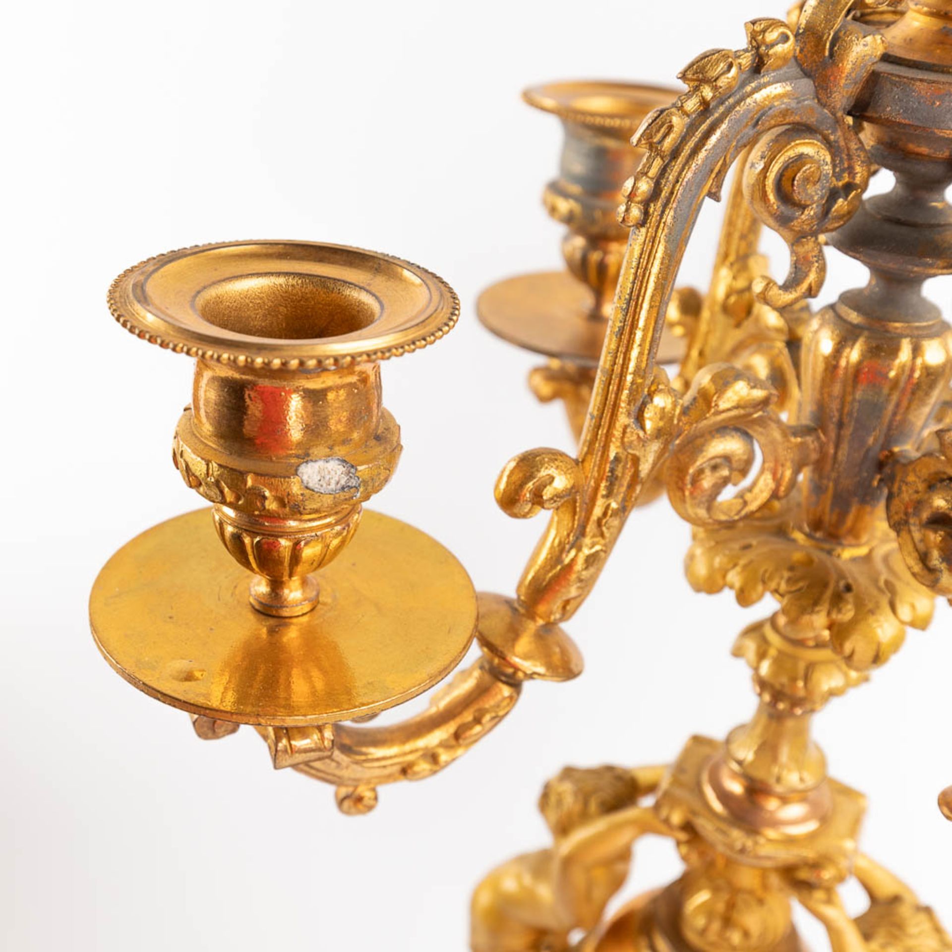 A three-piece mantle garniture clock and candelabra, gilt spelter, decorated with putti. Circa 1900. - Image 10 of 19