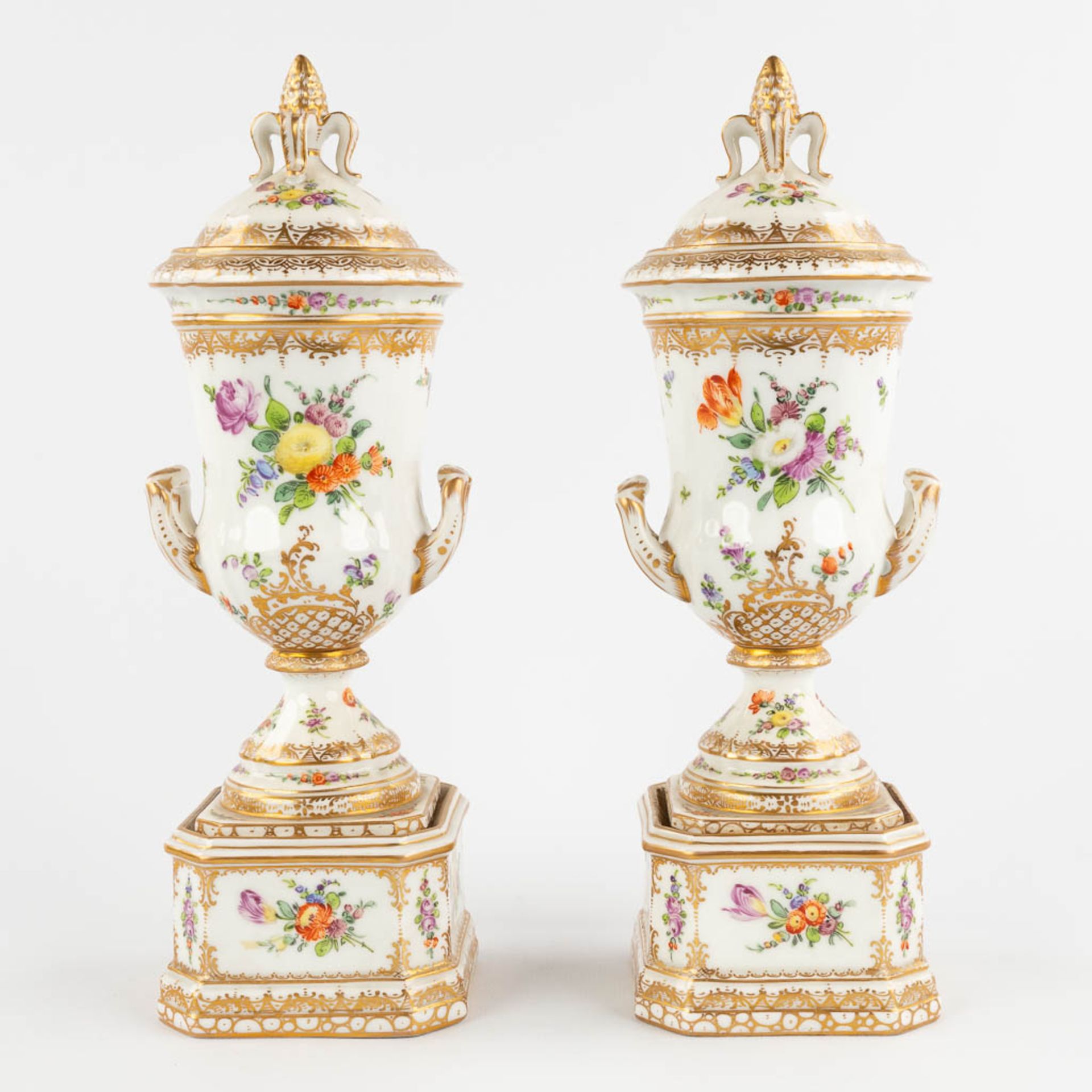 Dresden, a pair of polychrome urns with a lid. Hand-painted floral decor.  (D:8,5 x W:9 x H:26 cm)