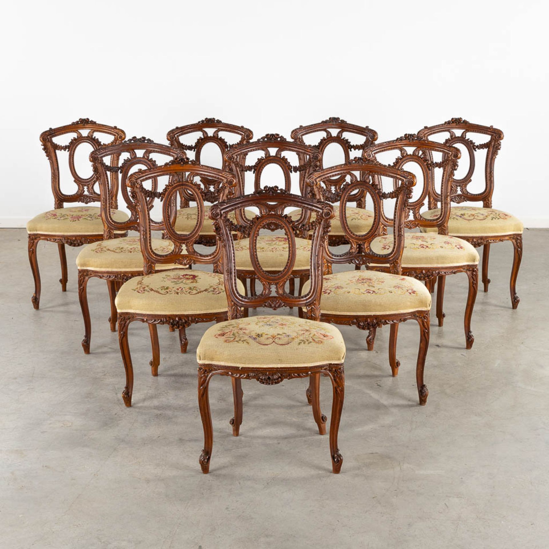 An exceptional set of 10 chairs, finely sculptured wood and embroideries in Louis XVI style. (L:51 x