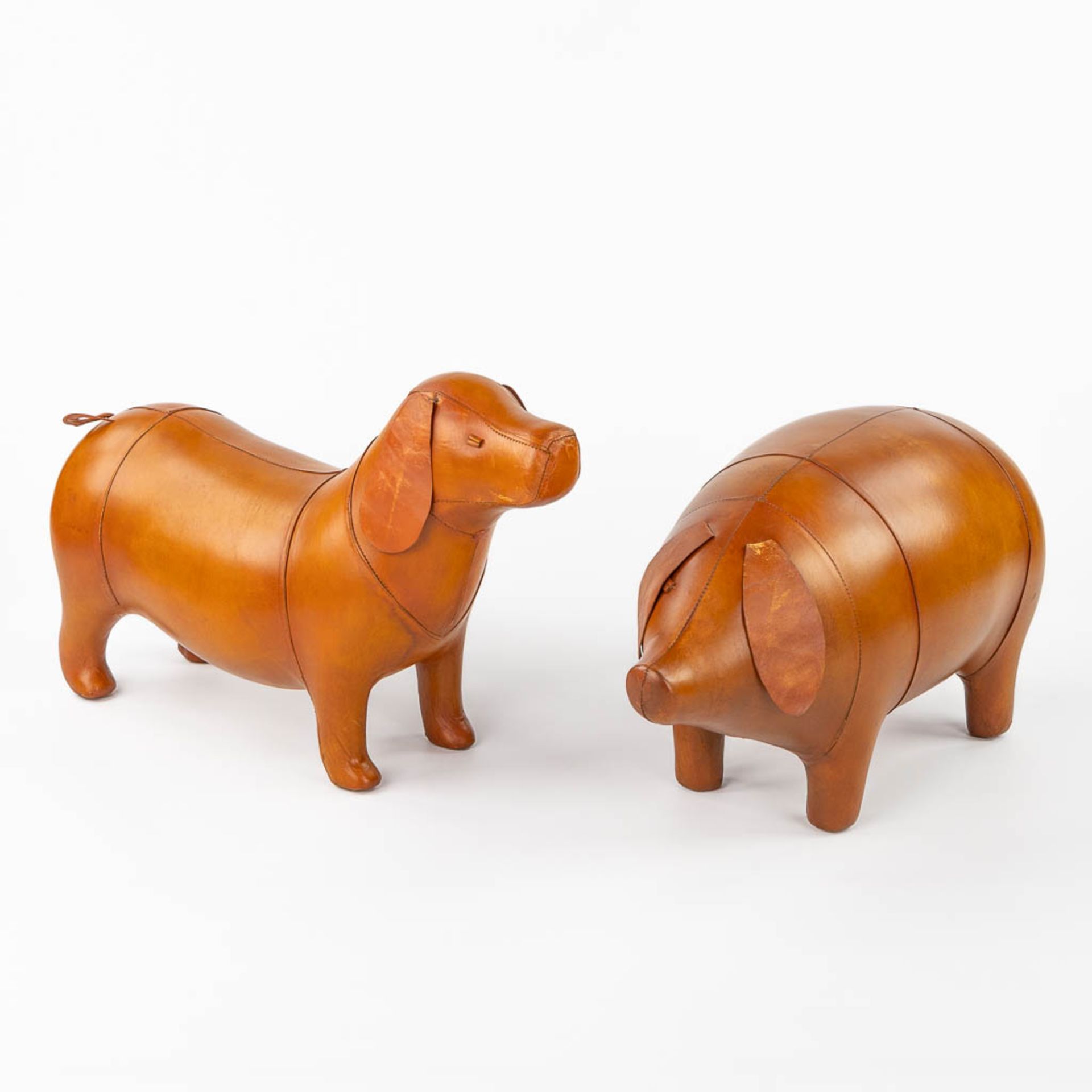 Two footstools, leather, Pig and Dog, in the style of Dimitri Omersa. (L:25 x W:70 x H:46 cm)
