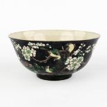 A Chinese Famille Noir bowl, decorated with fauna and flora. 19th C. or older. (H:7,5 x D:16,5 cm)