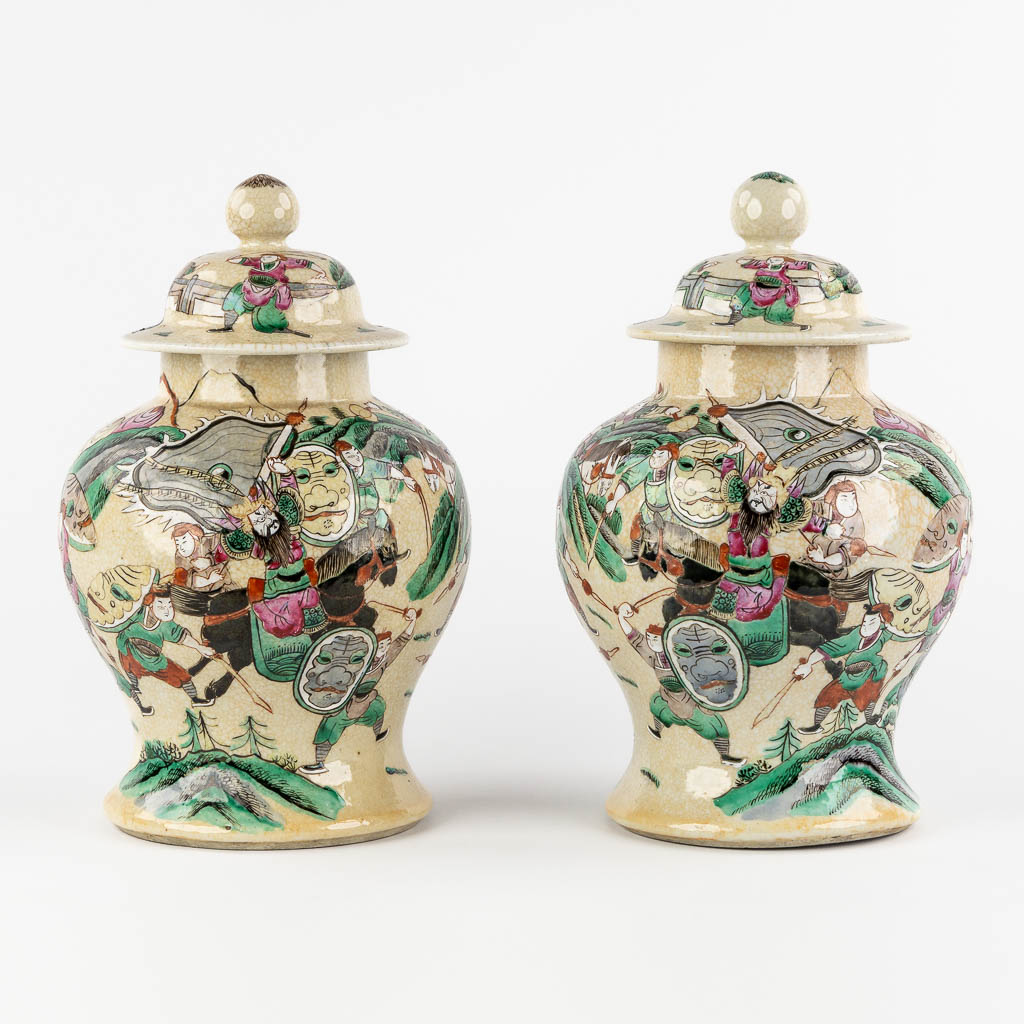 A pair of Chinese Nanking Baluster vases with covers, decorated with warrior scnes. (H:32 x D:19 cm