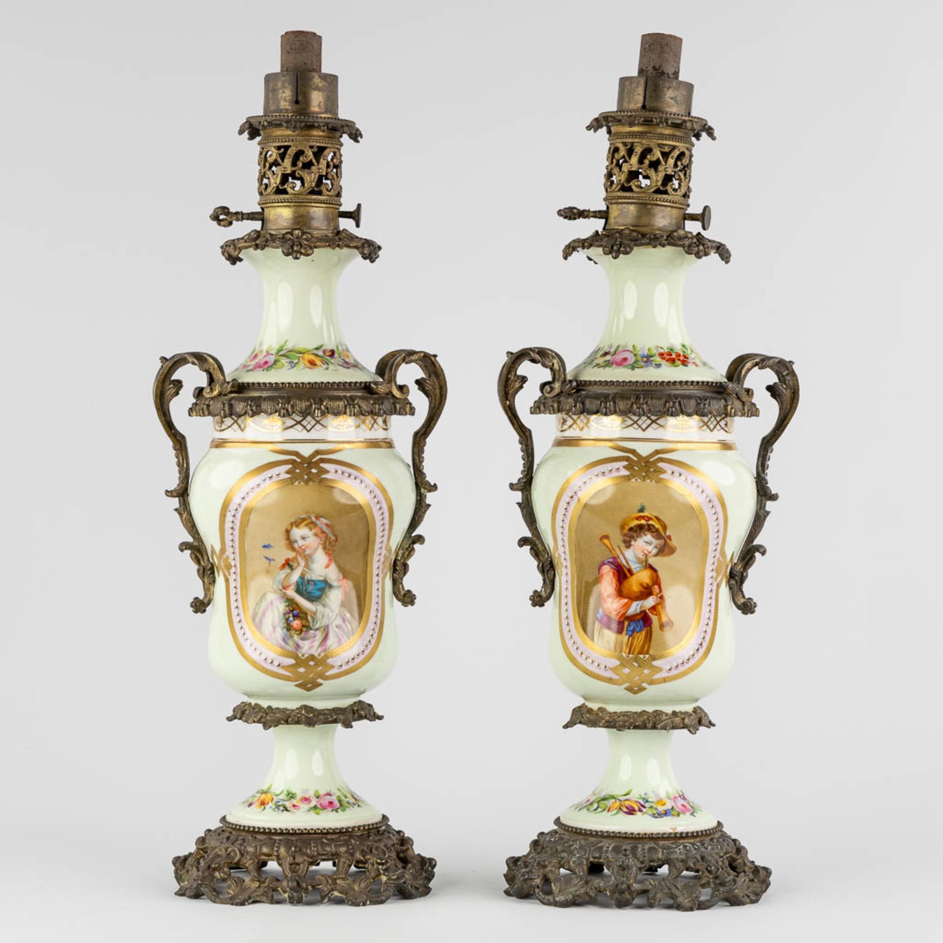 A pair of oil lamps with hand-painted decors, mounted with bronze. 19th C. (L:18 x W:20 x H:57 cm)
