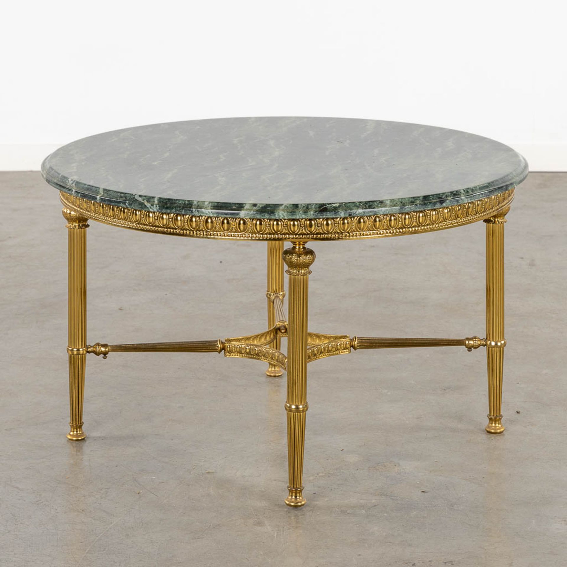 A brass coffee table with a green marble top. (H:46 x D:80 cm)