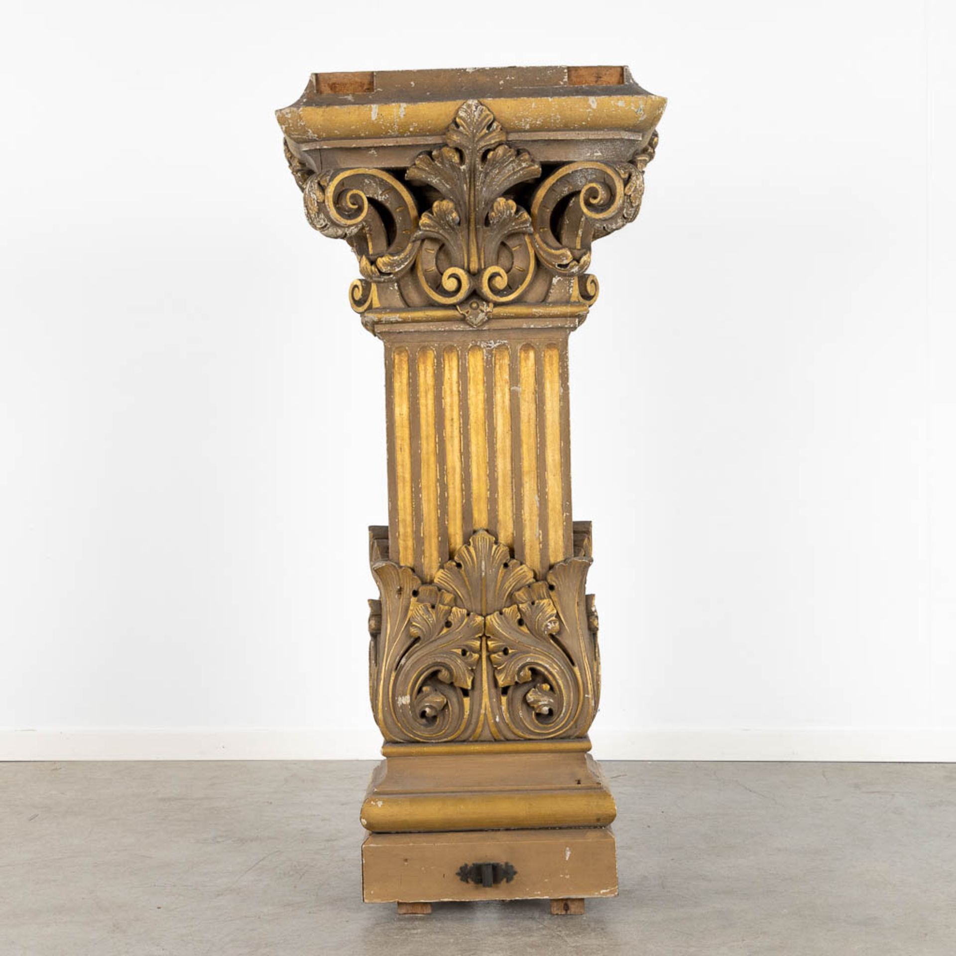 A richly gilt and woodsculptured pedestal with an ionic capitel. Circa 1900. (L:44 x W:60 x H:130 cm