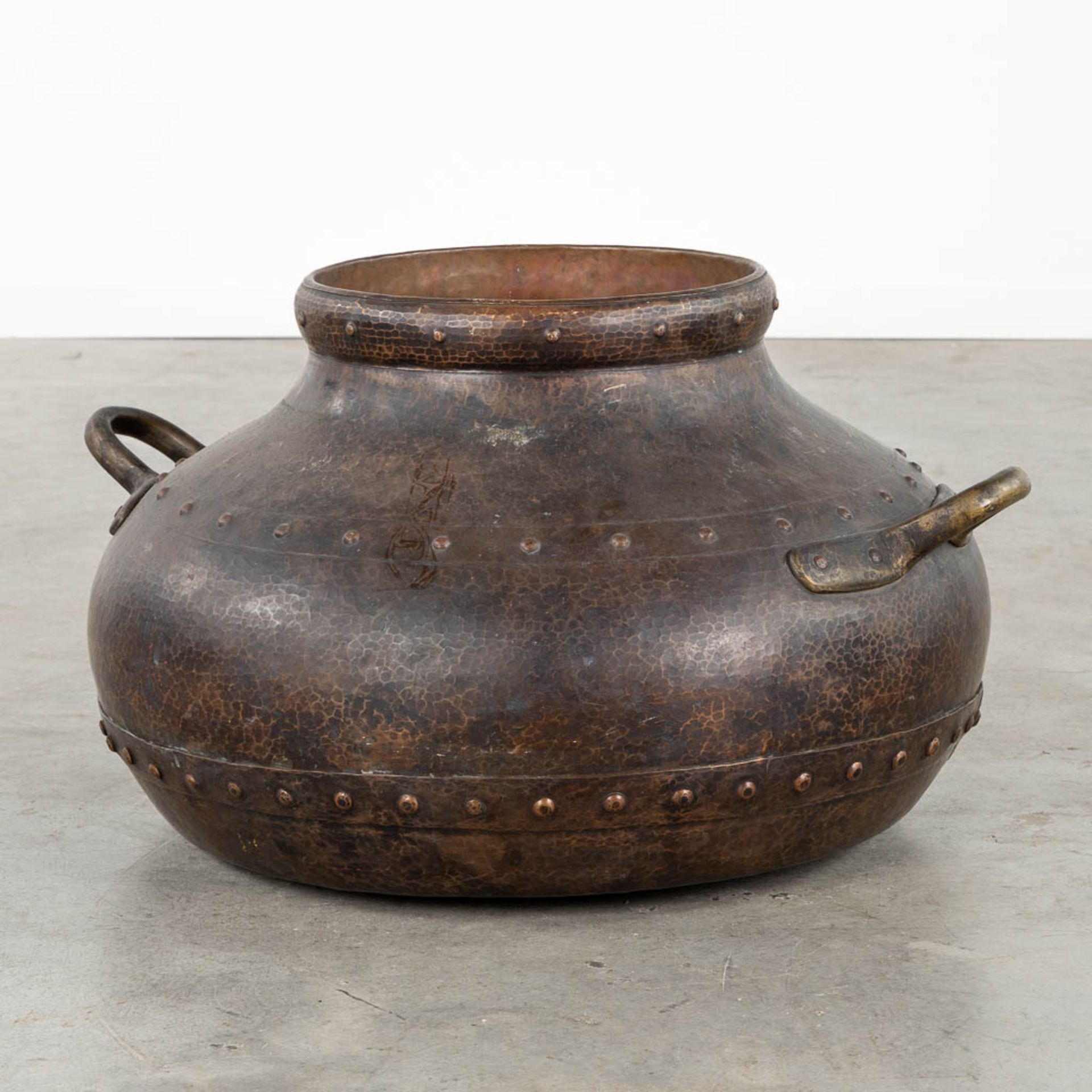 A large kettle, copper with brass rivets. (L:70 x W:80 x H:45 cm)