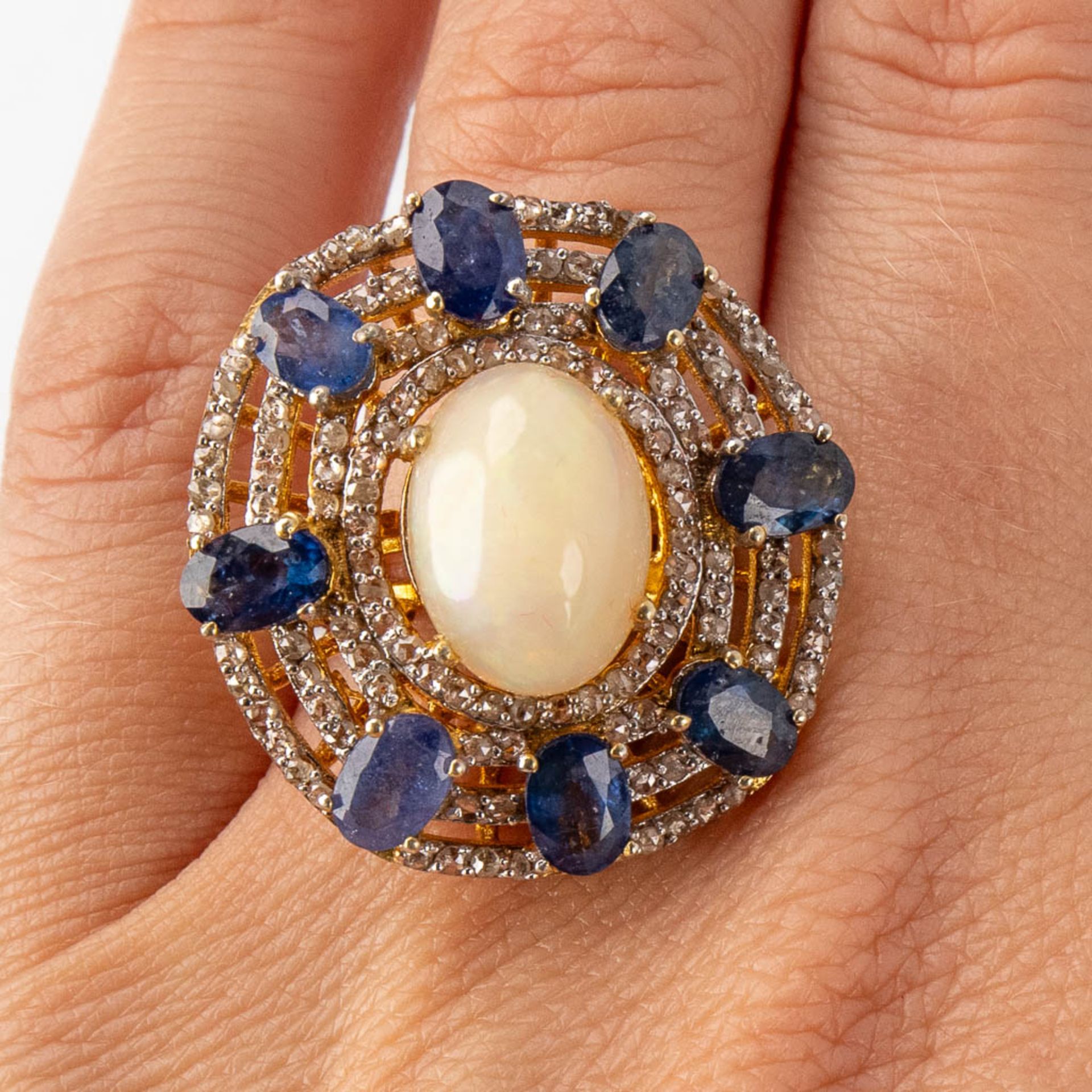 A ring, gilt silver with an Opal, sapphires, opal and 'old cut' diamonds. Ring size: 57. 10,26g.