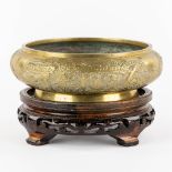 A Chinese bronze insence burner, standing on a wood base. (H:6,5 x D:22 cm)