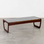 A mid-century coffee table with a glass top, probably teak. Circa 1970. (L:130 x W:30 x H:40 cm)