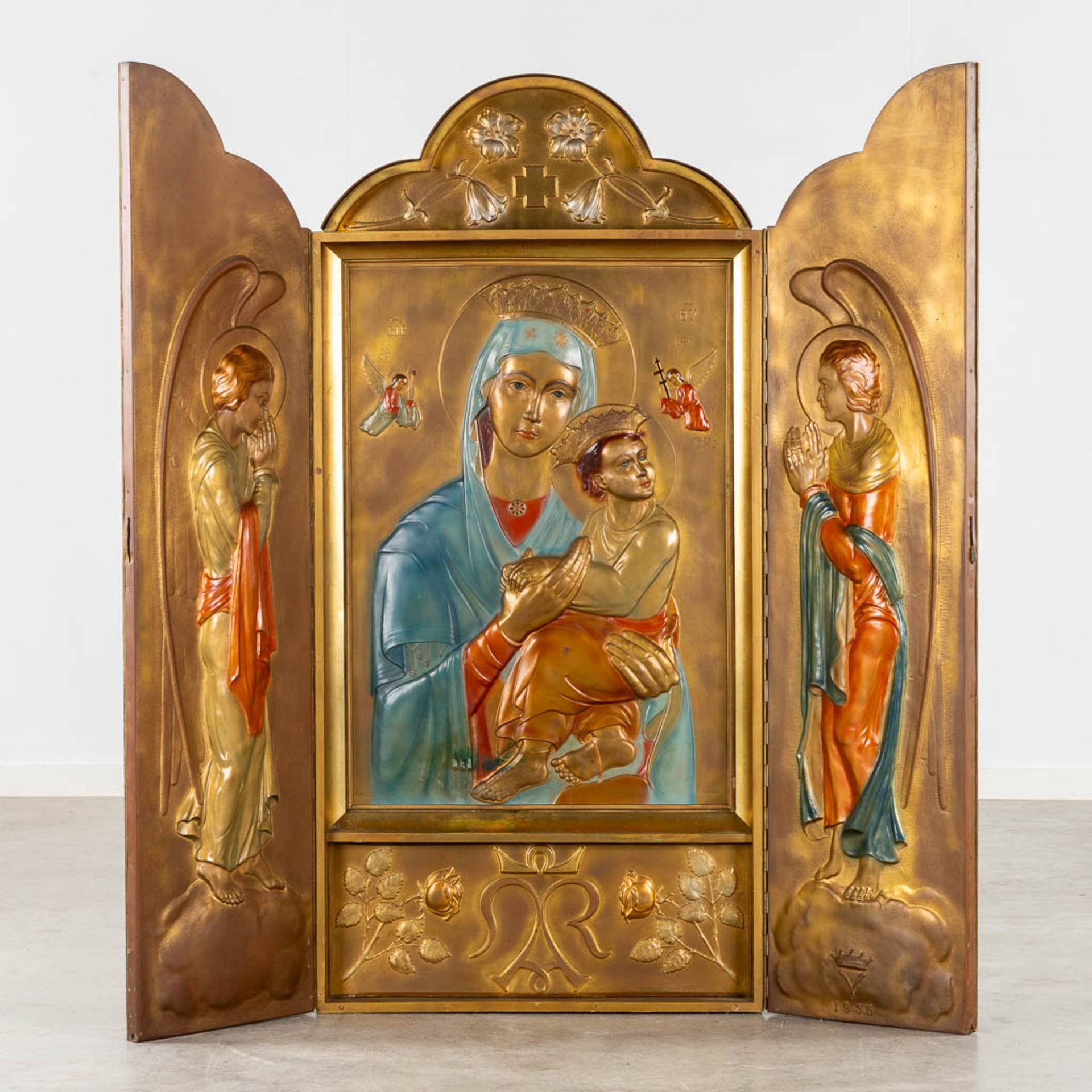 A large triptych, wood and repousse copper, patinated with images of Madonna with Child and Angels.