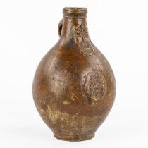 An antique 'Bartmann' jug with a seal on the belly, dated 1654. (H:28,5 x D:17 cm)