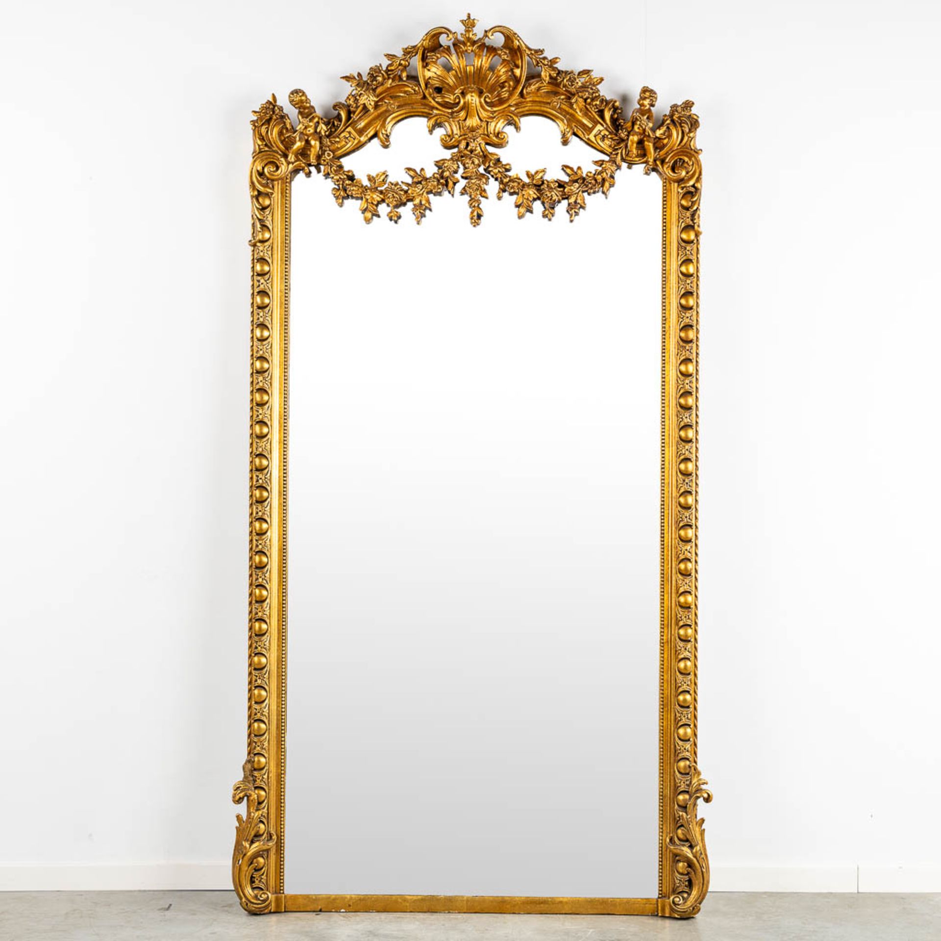 A mirror, sculptured wood, and stucco in a Louis XV style. 20th C. (W:110 x H:218 cm)
