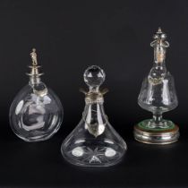 Three carafes, glass mounted with silver. Added a silver and wood bottle stand. (H:28 x D:12 cm)