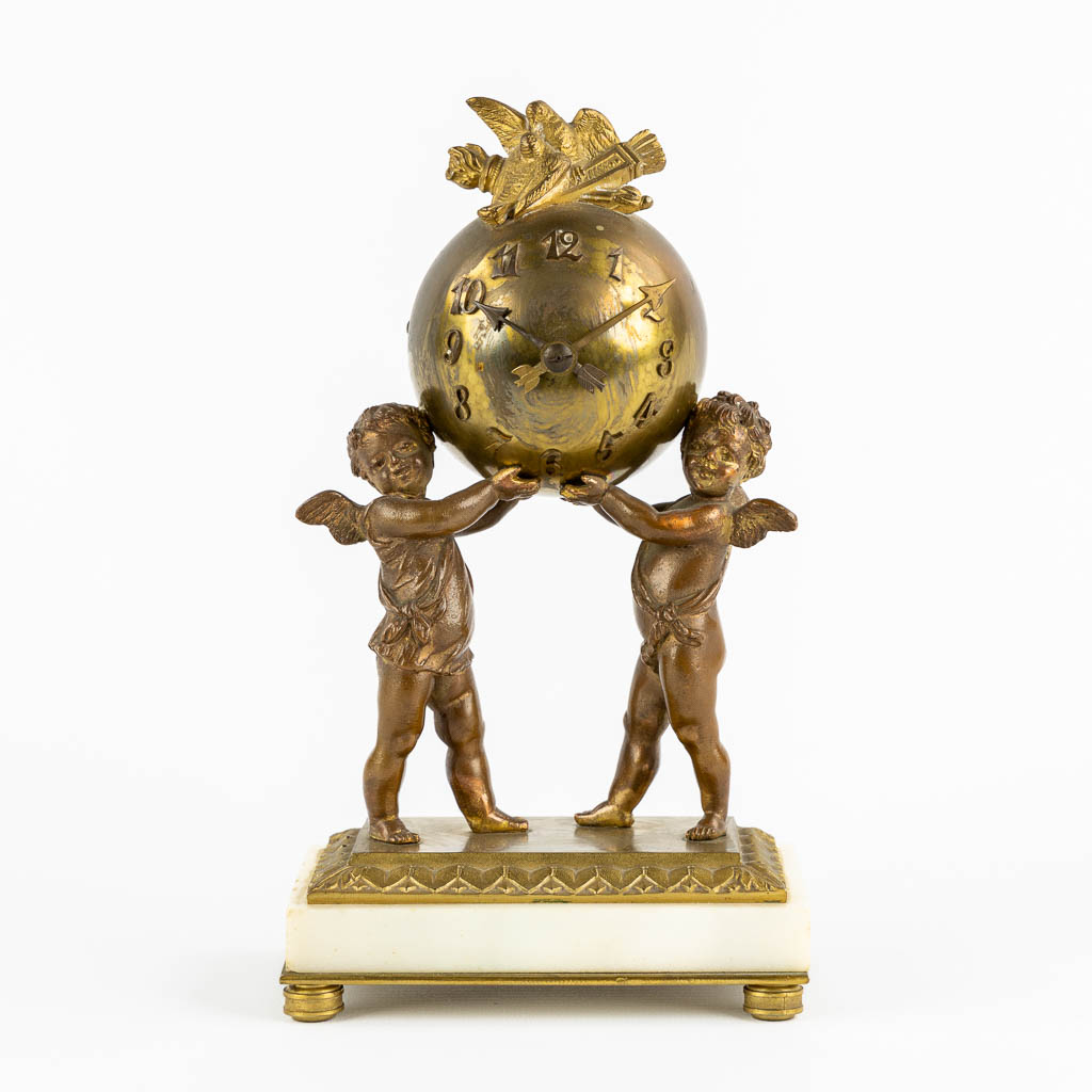 A Louis XVI style Mantle Clock, Putti holding a globe. Gilt bronze. Circa 1900. (L:8 x W:12 x H:21 c
