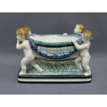 Secessionist table centrepiece with four cherubs carrying a basket with floral garlands, on a