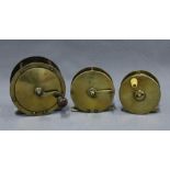 Large brass salmon fishing reel and two smaller brass trout fishing reels, one signed to the