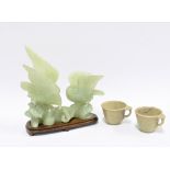 Carved jadeite group of two birds, on a wooden stand, 21cm long, together with two jadeite cups (3)