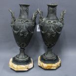A pair of classical style metal vases, twin handled with coloured hardstone bases, on gilded feet (