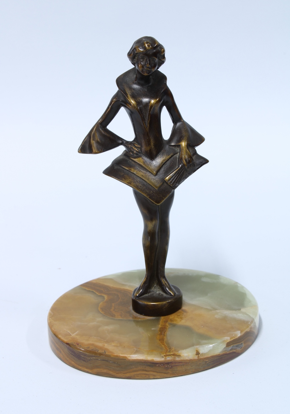 Art Deco style bronze patinated metal figure of a girl in stylistic dress, on a hardstone base, 15cm