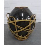 Large Chinese brown glazed wine pot, in a basket. 41cm.