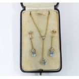 A pair of 9ct gold aquamarine and pearl drop earrings with a knife edge bar suspending a group of