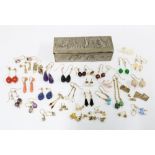 A quantity of earrings to include gold, silver and costume examples contained within a small white