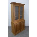 Large pine cabinet, cornice top with dentil frieze over two glazed doors with a shelved interior