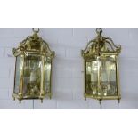 Pair of heavy brass lantern style wall lights with glazed panels, three internal candle style