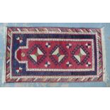 Kazak prayer rug, the red mihrab enclosing three hooked medallions 130 x 70cm.