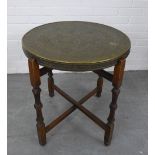 Benares style table with circular brass engraved tray top and folding wood base . 64 x 60cm.