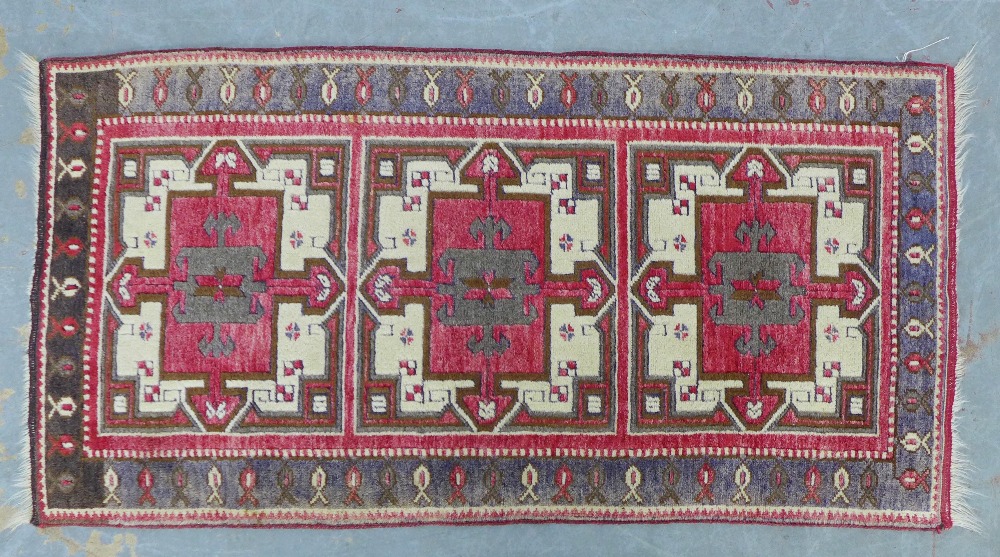 Caucasian rug, red field with three square panels enclosing stylised flowerheads, single border, 141