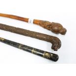 Chinese walking cane with allover carved pattern and dragons head handle, a Japanese black lacquered