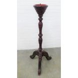 Chinoiserie torchere / candle sconce on an ebonised column with tripod legs. 113 x 45cm.