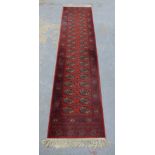 Afghan Bokhara runner, red field with two rows of guls within a flowerhead border, fringed ends