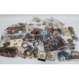 A large collection of costume jewellery to include brooches, beads, necklaces, bangles and earrings,