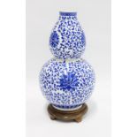 Chinese blue and white double gourd vase, attached to the hardwood base, 32cm high.