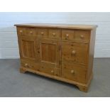 Pine dresser, the rectangular top over an arrangement of drawers and two cupboard doors. 91 x 129