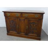 An oak sideboard, moulded rectangular top above two short frieze drawers and two cupboard doors