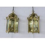 Pair of heavy brass lantern style wall lights with glazed panels, three internal candle style